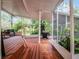 Spacious screened-in back porch with wood and brick flooring, a grill, seating and lush backyard views at 2004 Magnolia Ave, Sanford, FL 32771
