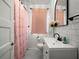 This traditional bathroom features a black and white tiled floor and a pink shower curtain at 2004 Magnolia Ave, Sanford, FL 32771