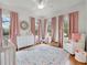 Charming Bedroom with pastel pink accents, including curtains, decor, and a patterned area rug at 2004 Magnolia Ave, Sanford, FL 32771