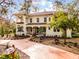 Elegant two-story home boasts a charming facade, complemented by a terra cotta-colored driveway and lush landscaping at 2004 Magnolia Ave, Sanford, FL 32771