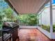 Screened back porch with brick flooring and view of the backyard landscape at 2004 Magnolia Ave, Sanford, FL 32771