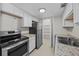 Modern kitchen with white cabinets, stainless steel appliances, and granite countertops at 208 Diamond Cv # 104, Casselberry, FL 32707