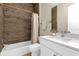 Clean bathroom with white vanity, tub, and wood-look tile at 2309 Depauw Ave, Orlando, FL 32804