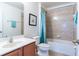 Clean bathroom with tub shower, vanity, and tiled walls at 2553 Dharma Cir, Kissimmee, FL 34746
