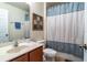 Bathroom featuring blue accented shower curtain, sink, and toilet at 2553 Dharma Cir, Kissimmee, FL 34746