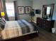 King bed, dresser, TV and large windows in this bright bedroom at 2553 Dharma Cir, Kissimmee, FL 34746