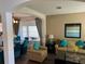 Living room with bay window, neutral color palette, and teal accents at 2553 Dharma Cir, Kissimmee, FL 34746