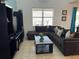 Living room with sectional sofa, coffee table, and large TV at 2553 Dharma Cir, Kissimmee, FL 34746