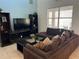 Living room featuring large windows and a comfortable brown sectional sofa at 2553 Dharma Cir, Kissimmee, FL 34746
