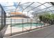 A screened in pool is surrounded by white privacy fence at 2553 Dharma Cir, Kissimmee, FL 34746