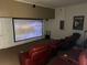 Home theater with projector screen and red leather reclining seats at 2553 Dharma Cir, Kissimmee, FL 34746
