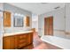 Bathroom with granite countertops, wood cabinets, and a clawfoot tub at 26225 Pitts Rd, Eustis, FL 32736