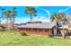 Ranch style home with metal roof, large porch, and fenced yard at 26225 Pitts Rd, Eustis, FL 32736
