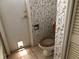 Bathroom with toilet, shower, and patterned wallpaper at 34847 Learn Rd, Leesburg, FL 34788