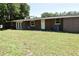 Back exterior view of the house showing a large lawn and access to the inside at 423 Longfellow Blvd, Lakeland, FL 33801