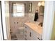 Bright bathroom with tiled floors, white vanity and natural light through a window at 423 Longfellow Blvd, Lakeland, FL 33801
