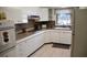 Bright kitchen features white appliances, tiled flooring, granite countertops and natural light through a window at 423 Longfellow Blvd, Lakeland, FL 33801