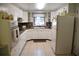 Bright kitchen features white appliances, tiled flooring, granite countertops and natural light through a window at 423 Longfellow Blvd, Lakeland, FL 33801