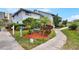Condo entrance with landscaped walkway and accessible path, featuring lush tropical plants at 4411 Sea Mist Ct # 174, New Smyrna Beach, FL 32169