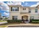 Charming two-story townhouse featuring a well-maintained lawn and covered entryway with neutral colored facade at 4800 Memories Ln, Kissimmee, FL 34746