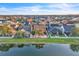 Expansive aerial view of a neighborhood featuring homes, lawns, and a serene pond reflecting the sky at 4912 Atwood Dr, Orlando, FL 32828