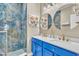 This updated bathroom has a bright blue vanity with dual sinks and a luxurious tiled shower at 4912 Atwood Dr, Orlando, FL 32828