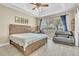 Cozy bedroom featuring a wooden bed frame, tray ceiling, ample natural light, and a view of the yard at 4912 Atwood Dr, Orlando, FL 32828