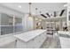Modern kitchen boasting a large island, pendant lights, white cabinetry and a view to the outdoor patio at 4912 Atwood Dr, Orlando, FL 32828