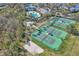 Aerial view of well-kept tennis courts and sand volleyball court amidst lush greenery and a community pool at 4912 Atwood Dr, Orlando, FL 32828