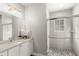 Modern bathroom featuring a glass-enclosed shower with pebble flooring, white vanity with marble countertop at 506 Yellow Submarine Ct, Groveland, FL 34737