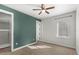 Bedroom with green accent wall, ceiling fan, and walk-in closet at 506 Yellow Submarine Ct, Groveland, FL 34737