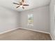 Cozy bedroom with neutral walls, carpeted flooring, ceiling fan and a window providing natural light at 506 Yellow Submarine Ct, Groveland, FL 34737