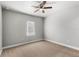 Simple bedroom with a ceiling fan and a window letting in natural light, carpeted floor, neutral walls at 506 Yellow Submarine Ct, Groveland, FL 34737