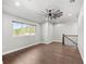 Spacious bonus room with wood floors, large window, and ceiling fan at 506 Yellow Submarine Ct, Groveland, FL 34737