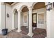 Elegant entryway with arched columns, tile accents, and a double door at 506 Yellow Submarine Ct, Groveland, FL 34737
