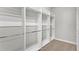 Bright walk-in closet featuring metal hanging rods and carpeted floor; ample storage for clothing and accessories at 506 Yellow Submarine Ct, Groveland, FL 34737