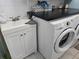 White washer and dryer with a utility sink and cabinet at 534 Sabal Trail Cir, Longwood, FL 32779