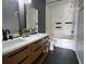 Modern bathroom featuring a double vanity sink, modern fixtures, and a bathtub with white tile surround at 5518 Metrowest Blvd # 104, Orlando, FL 32811