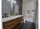 Modern bathroom featuring a double vanity sink, modern fixtures, and a bathtub with white tile surround at 5518 Metrowest Blvd # 104, Orlando, FL 32811