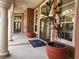 Elegant clubhouse entrance with decorative columns, lush potted plants and double doors at 5518 Metrowest Blvd # 104, Orlando, FL 32811