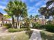 Beautifully landscaped community with a gated entrance, mature palm trees, and inviting pathways at 5518 Metrowest Blvd # 104, Orlando, FL 32811