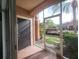 Enclosed back patio with view of lawn area, trees and glimpses of the Community Pool area at 5518 Metrowest Blvd # 104, Orlando, FL 32811
