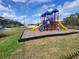 Community playground with play equipment and swings surrounded by green space at 5518 Metrowest Blvd # 104, Orlando, FL 32811