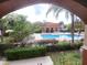 View of community pool area with lush landscaping as seen from patio at 5518 Metrowest Blvd # 10, Orlando, FL 32811