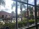View of community pool area with lush landscaping seen through window at 5518 Metrowest Blvd # 104, Orlando, FL 32811
