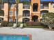 Scenic view of the pool area surrounded by palm trees and well-maintained landscaping, ideal for relaxation at 5518 Metrowest Blvd # 104, Orlando, FL 32811