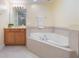 A bathtub and natural wood vanity in this relaxing, well-lit bathroom at 7189 Regina Way, Orlando, FL 32819