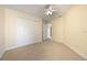 Bedroom featuring carpet, a ceiling fan, a double door closet, and neutral paint at 7189 Regina Way, Orlando, FL 32819