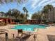 Relax at the community pool with palm trees, lounge chairs, and pergola-covered seating areas at 7189 Regina Way, Orlando, FL 32819