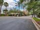 Community entrance with palm trees and lush landscaping, offering a secure and welcoming entry at 7189 Regina Way, Orlando, FL 32819